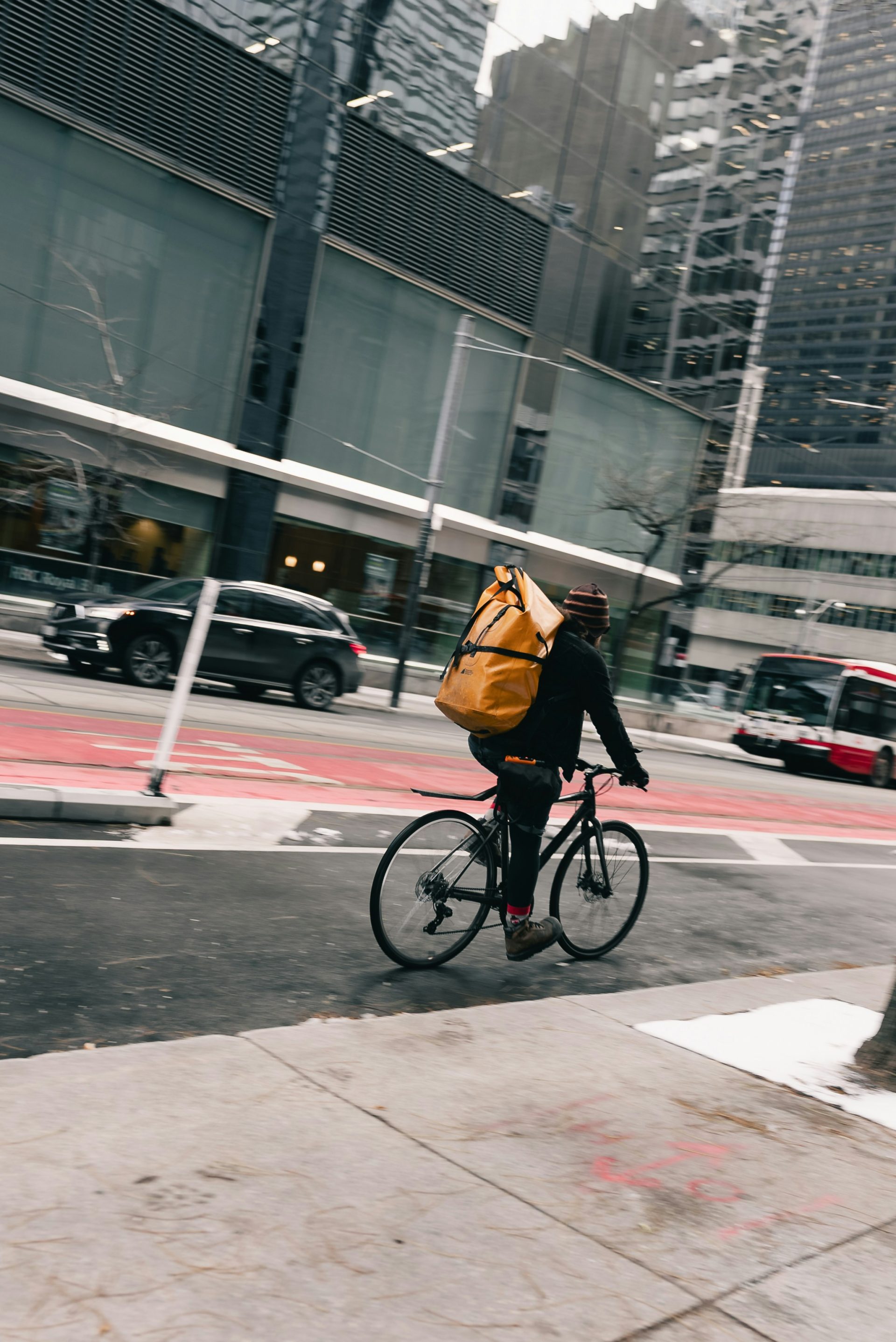 Radfahrer mit großer gelber Tasche navigiert durch die Stadtstraße